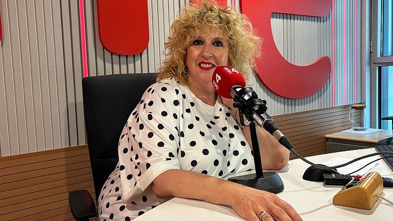 La periodista S�lvia Tarragona sonr�e en el estudio de R�dio 4 ante una mesa con micr�fono y equipamiento de audio.