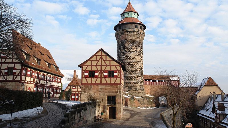 Patio interior del Castillo Imperial de N�remberg en invierno, con la Torre Sinwell y edificios medievales tradicionales con tejados nevados.