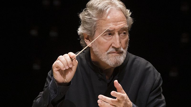 Plano medio del director Jordi Savall concentrado en un concierto, sosteniendo una batuta con expresi�n intensa sobre fondo negro.