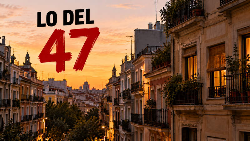 Vista elevada de una calle urbana al atardecer con edificios residenciales y el rótulo 'LO DEL 47' en la esquina superior izquierda.
