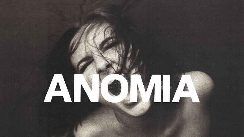 Retrato en blanco y negro de la cantante Ruslana con expresi�n intensa y la palabra ANOMIA en grandes letras blancas sobre su rostro.