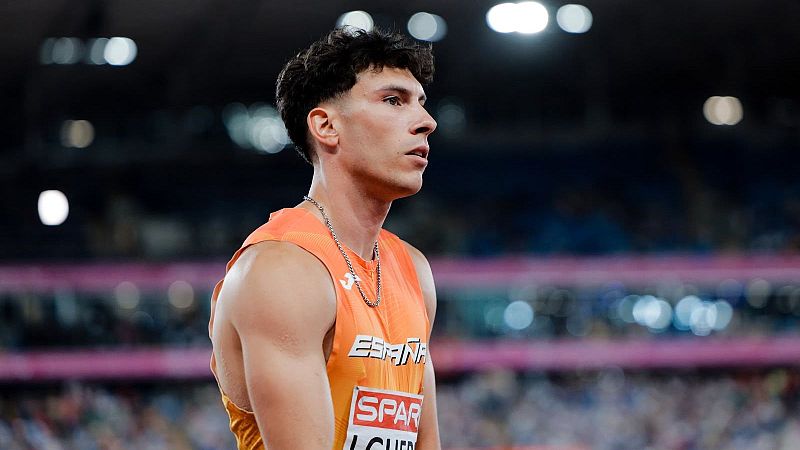 Plano medio del atleta Jaime Guerra con camiseta naranja de Espa�a y dorsal SPAR en un estadio iluminado de noche.