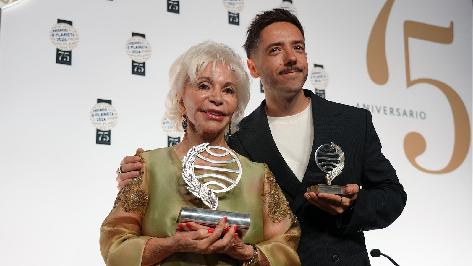 Isabel Allende i Sergio Hernández somriuen sostenint els trofeus del Premi Planeta davant d'un photocall institucional.