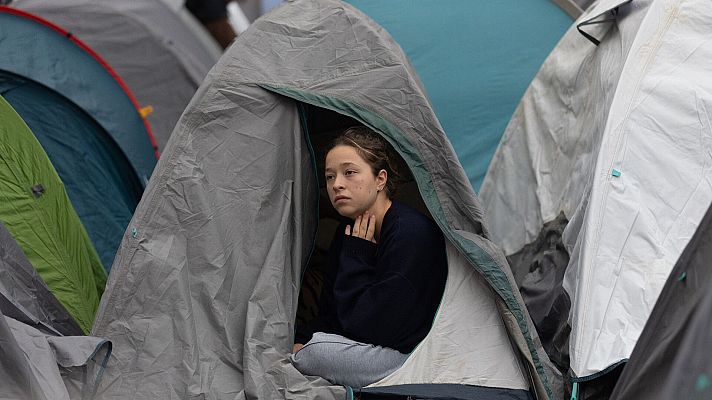 Una joven con expresión seria en una tienda de campaña durante la acampada por la vivienda en la Puerta del Sol en Madrid
