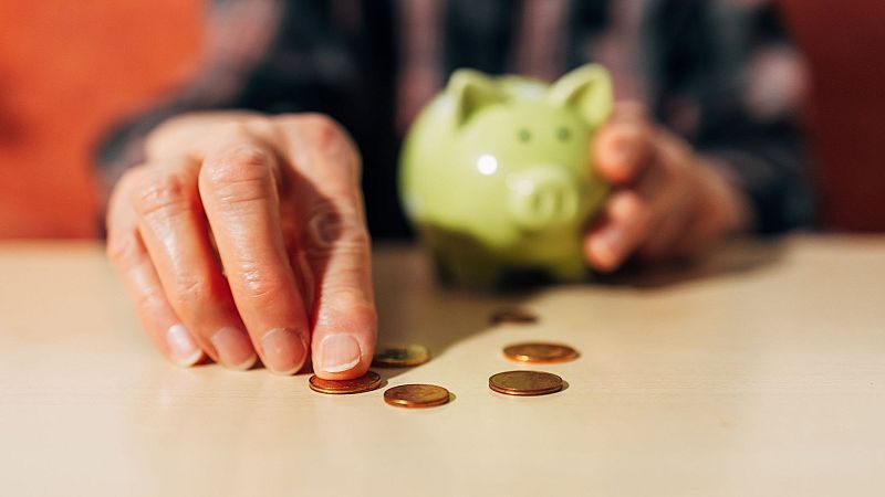 Imagen de un pensionista metiendo dinero en una hucha