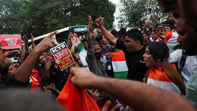 Manifestación callejera en la India con jóvenes activistas protestando enérgicamente, alzando pancartas y exigiendo el derecho al voto.