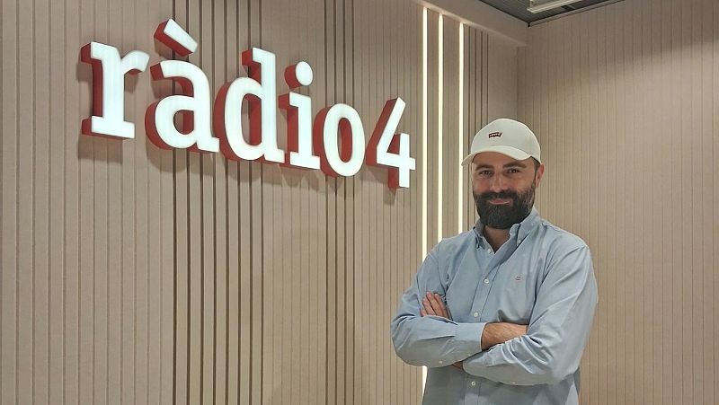 El periodista Joan Callarissa posa sonriente con los brazos cruzados en un estudio junto al logotipo luminoso de R�dio 4.