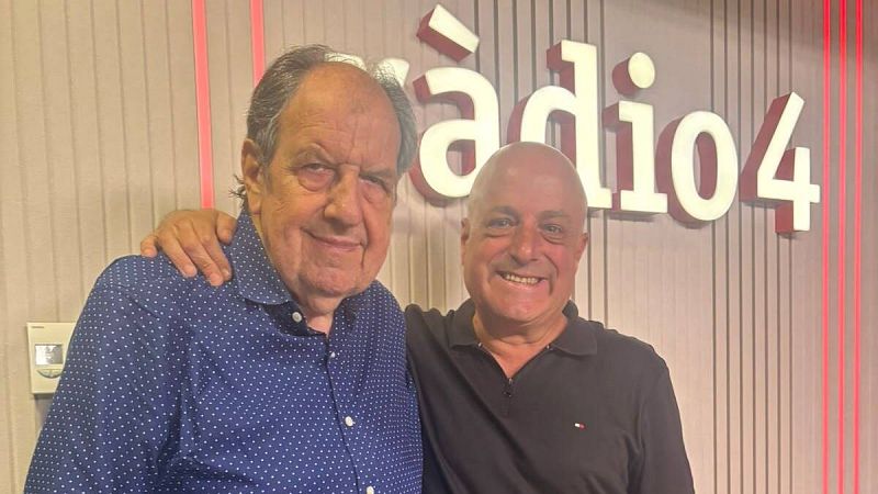 Dos hombres posan sonrientes en un estudio de radio con iluminaci�n c�lida y un letrero de R�dio 4 al fondo.