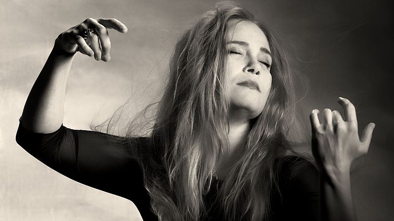 Fotograf�a en blanco y negro de la pianista H�l�ne Grimaud con los ojos cerrados y los brazos elevados en actitud de intensa concentraci�n musical.