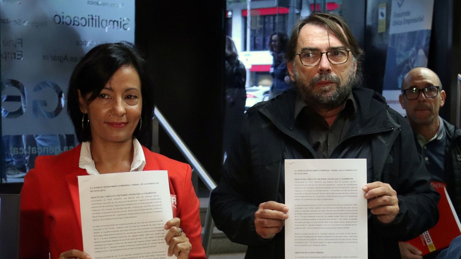 Los líderes sindicales Belén López y Camil Ros muestran a las cámaras el preaviso de huelga general frente a una sede administrativa.