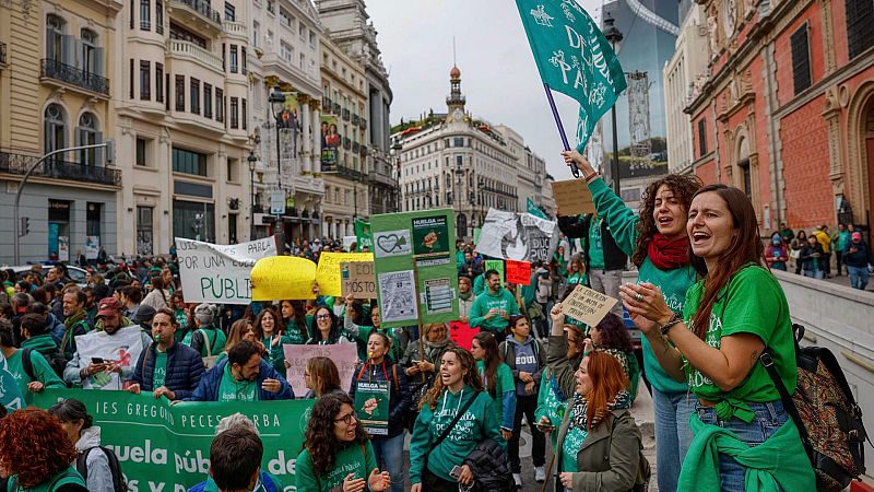 Manifestación multitudinaria de la Marea Verde en defensa de la educación pública en una avenida de Madrid, con pancartas y asistentes con ropa verde.