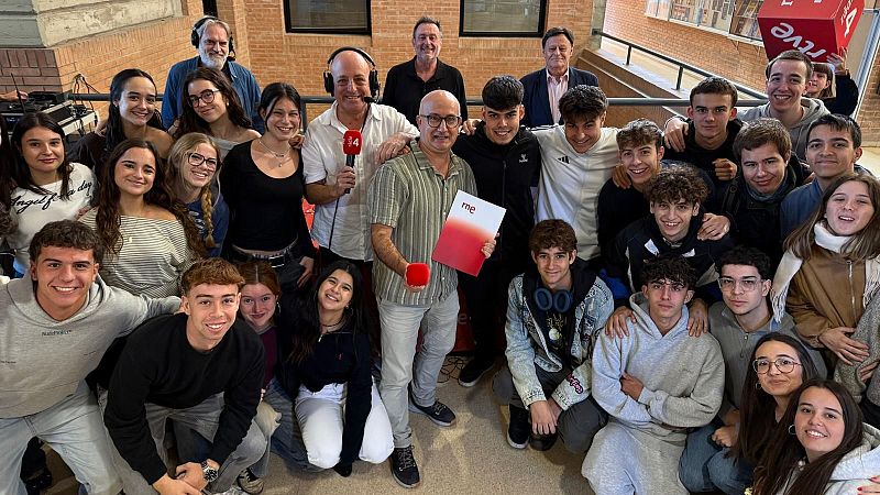 Dos profesionales de la radio con auriculares y micr�fonos de R�dio 4 posan sonrientes en un estudio de ladrillo junto a un grupo de j�venes estudiantes universitarios.