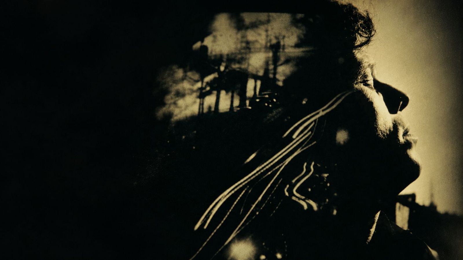 Retrato de perfil en tonos sepia y claroscuro del m�sico Tom Waits, con la cabeza inclinada y siluetas urbanas superpuestas.