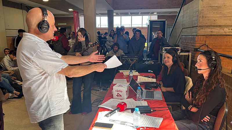 Tres locutores realizan un programa de radio en directo desde un espacio con ladrillo visto, acompa�ados de equipos t�cnicos y un cubo corporativo.