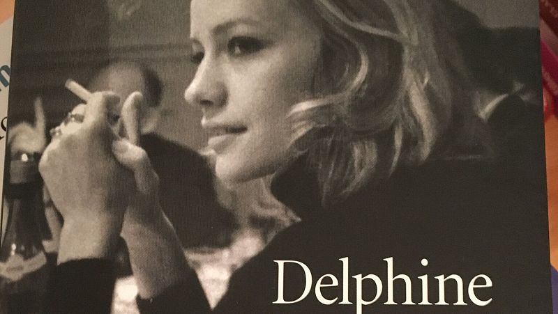 Primer plano en blanco y negro de perfil de la actriz Delphine Seyrig fumando un cigarrillo con expresi�n pensativa.