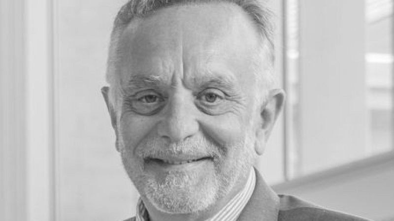 Fotograf�a en blanco y negro de Manel del Castillo sonriendo a la c�mara, con cabello corto, barba recortada y chaqueta formal.