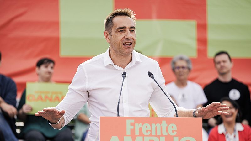 Plano medio de Emilio Delgado Orgaz hablando tras un atril con la inscripción «Frente AMPLIO», vistiendo camisa blanca y gesticulando.
