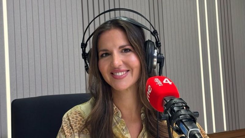 Georgina Badenas sonr�e en un estudio de radio con auriculares y micr�fono rojo con logotipos de RNE y R�dio 4, frente a una pared ac�stica.
