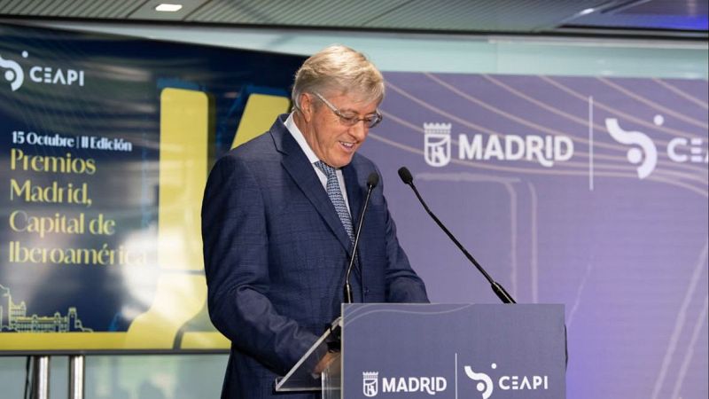 El empresario Jaime Gilinski Bacal ofrece un discurso en un acto oficial ante un atril con logotipos institucionales y una pantalla con el lema de los Premios Madrid, Capital de Iberoamérica.