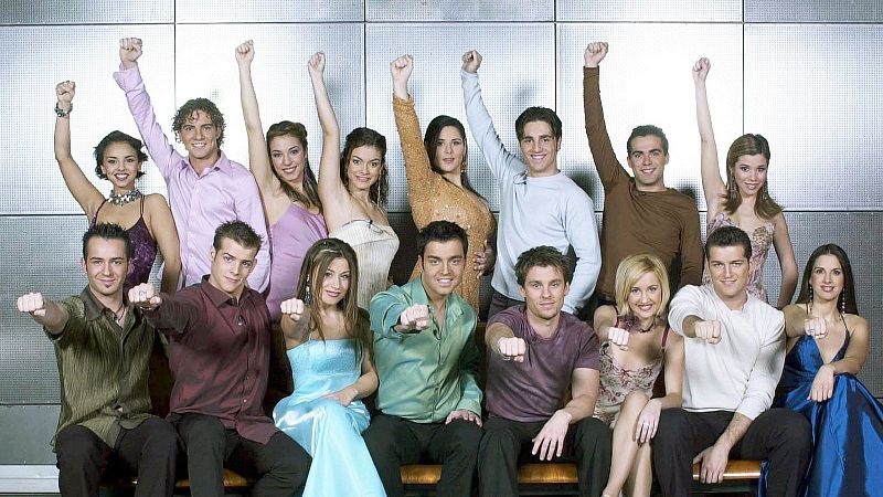 Fotograf�a grupal de los diecis�is concursantes de un programa musical posando juntos y alegres con ropa de fiesta ante un fondo met�lico.
