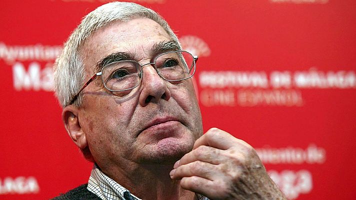Primer plano del guionista Rafael Azcona con gesto pensativo sobre fondo rojo corporativo.