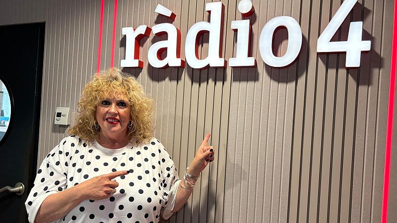 La periodista S�lvia Tarragona sonr�e y se�ala el logotipo de r�dio 4 en un estudio con paneles de madera y luces rojas.