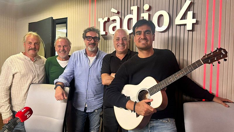 Cinco hombres posan sonrientes en un estudio de radio tras una emisi�n, destacando el cantautor �lvaro Soler con una guitarra ac�stica junto a cuatro miembros del equipo.