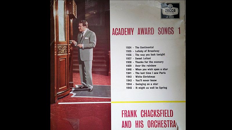 Portada del �lbum musical �Academy Award Songs 1� con la fotograf�a de un hombre con traje junto a un ascensor y la lista de canciones de 1934 a 1945.
