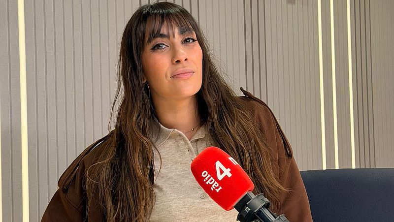 Miriam Saint Germain en un estudio de radio, sonriente ante la c�mara, con micr�fono profesional y fondo insonorizado.