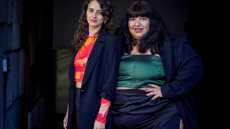 Fotografía en plano medio de las hermanas Yorka y Daniela Pastenes posando juntas con una iluminación frontal y suave sobre fondo oscuro.