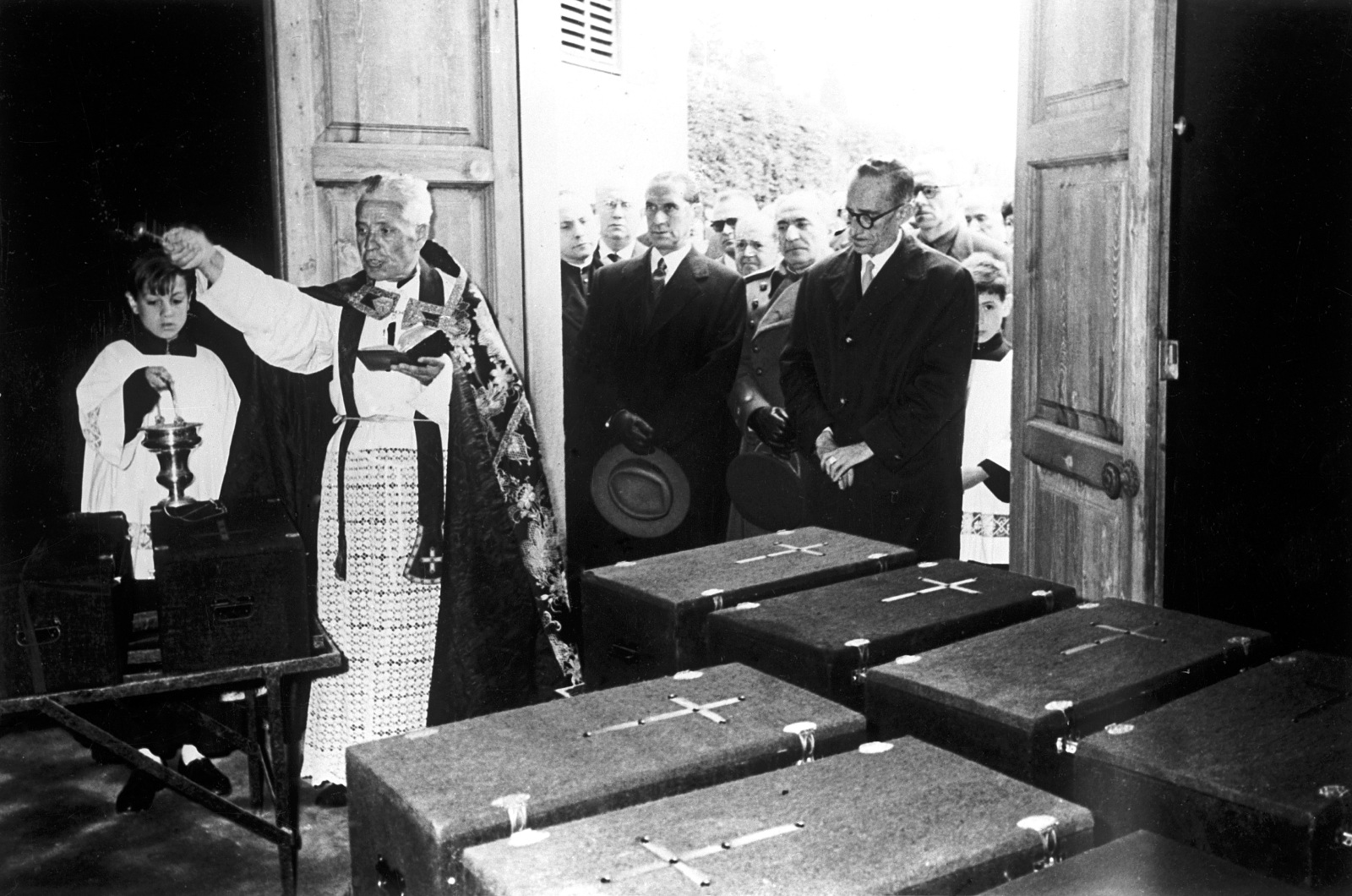 Barcelona: un sacerdote bendice las cajas preparadas para ser trasladadas a Cuelgamuros. EFE/Carlos Pérez de Rozas