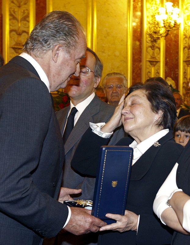 El Rey entrega a la viuda del ex presidente del Gobierno Leopoldo Calvo Sotelo, Pilar Ibañez-Martín, una medalla, en la capilla ardiente en el Congreso.