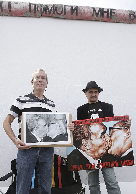 Russian artist Dmitry Vrubel and photographer Regis Bossu pose before restoration work on a segment of the East Side Gallery in Berlin