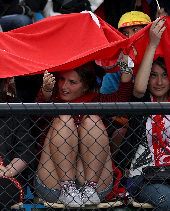 Varias espectadoras se protegen de la lluvia en el primer día de celebración del Abierto de Australia de tenis.