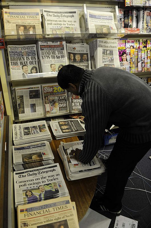 Un vendedor de prensa organiza los periódicos.