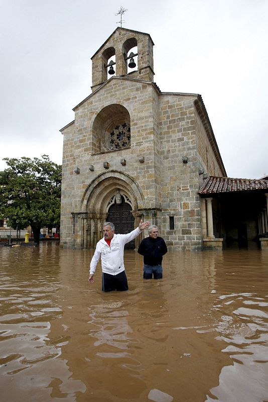 Dos ciudadanos de Villaviciosa (Asturias) tratan de evaluar los daños causados por las últimas lluvias.