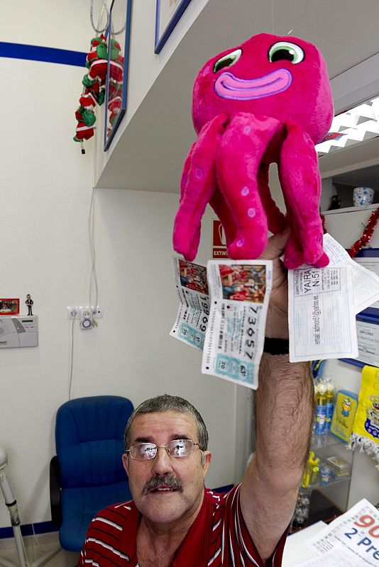 El dueño de la administración de Loteria número 51 de Las Palmas de Gran Canaria, muestra el que él llama el "hijo del pulpo Paul", donde tenía colgados varios números de la Loteria del Niño