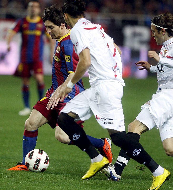 El delantero del Barcelona Messi sufre la presión de los sevillistas Martín Cáceres y Capel.