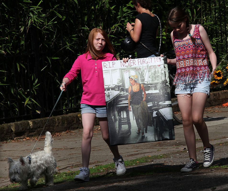 Dos niñas llevan un poster de Amy Winehouse al lugar al que se han acercado centenares de fans para rendirle tributo. La joven cantante había grabado dos discos, 'Frank' (2003) y 'Back to Black', que fue un éxito de ventas en todo el mundo.