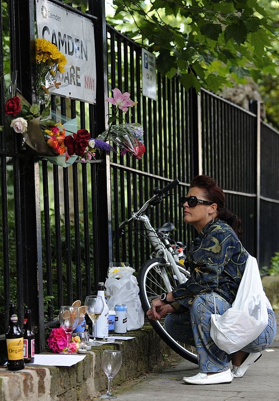Una mujer contempla el domicilio de la fallecida Amy Winehouse tras depositar flores como homenaje a la estrella británica. El éxito de la cantante, ganadora de varios premio Grammy, se vio empañado por sus adicciones.