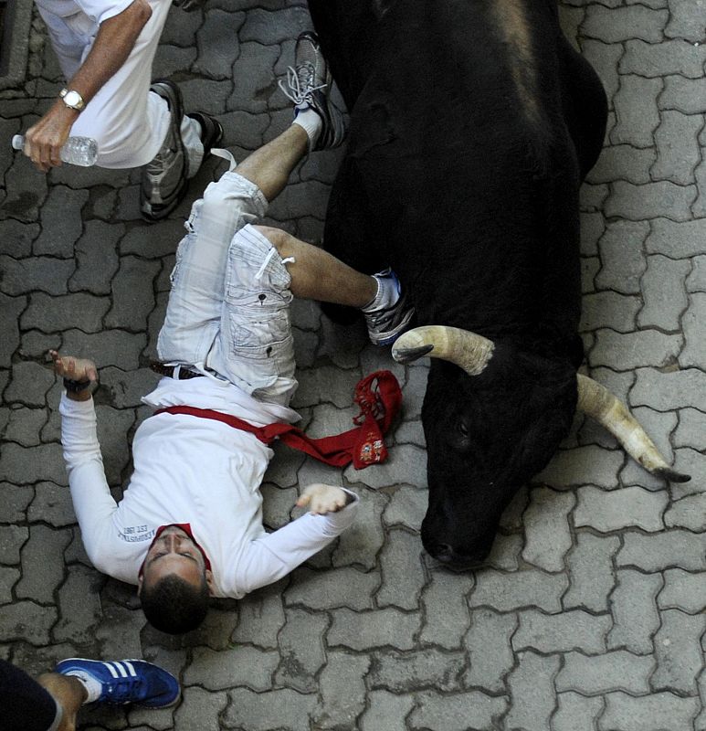 Uno de los morlacos arrolla a un mozo a la entrada al callejón.
