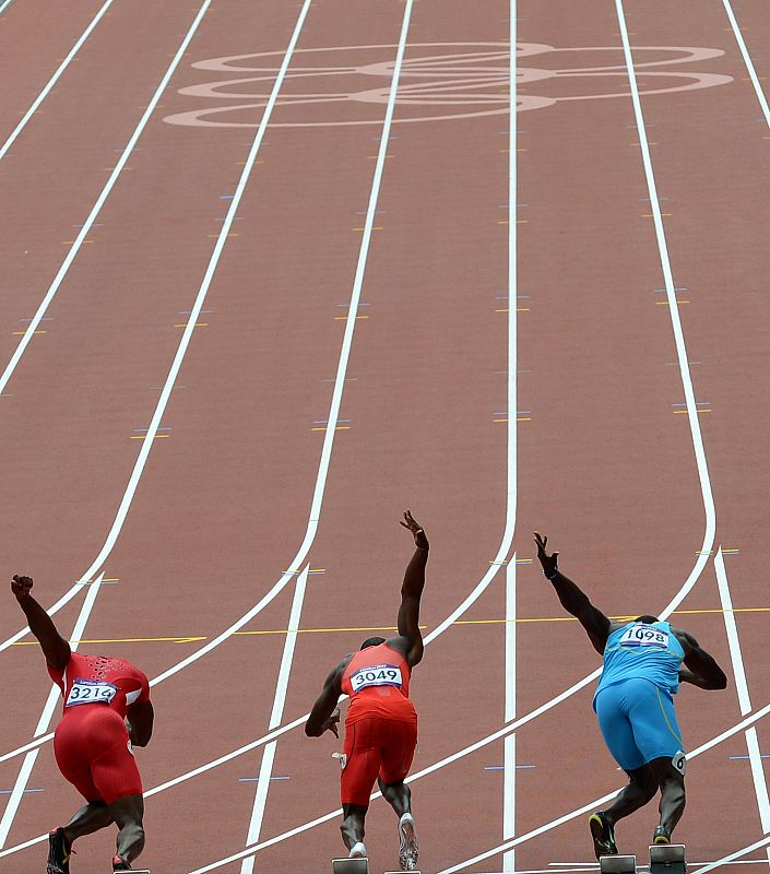 Justin Gatlin, Rondel Sorrillo y Derrick Atkins sobre los tacos de salida