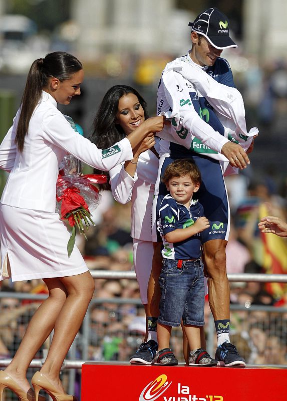 Second-placed Movistar Team's Valverde of Spain and his son Pablo is helped by attendants after the last stage of the Tour of Spain "La Vuelta" cycling race between Cercedilla and Madrid
