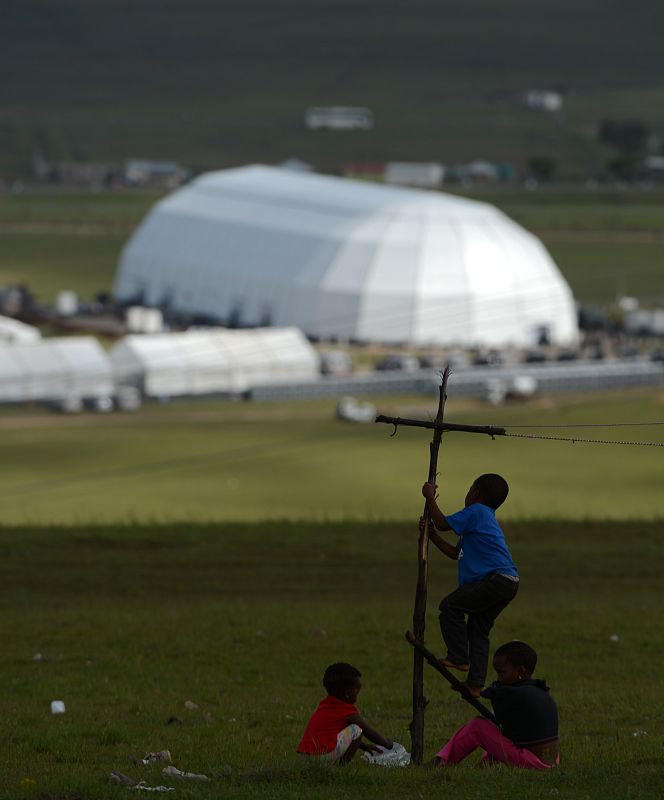 Niños juegan cerca de la carpa donde se celebra el funeral. Los vecinos de Qunu se han quedado por ser excluidos de la ceremonia