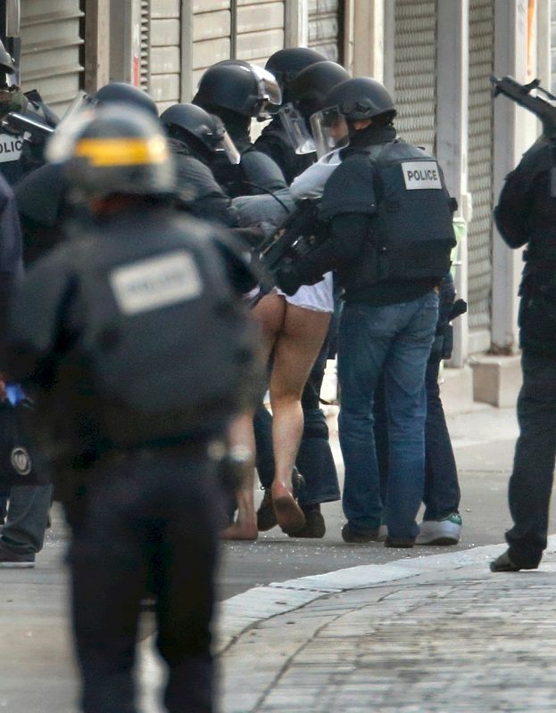 Uno de los detenidos es sacado por los agentes de la polícia antiterrorista francesa de la casa. Se trata de una operación lanzada para dar con el autor intelectual del atentado de París del viernes 13, en el que murieron 129 personas.