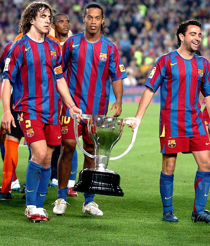 El capitán blaugrana Carles Puyol, con sus compañeros Xavi (d) y Ronaldinho, celebran la consecución de la Liga 2005-2006.