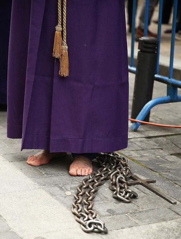 Un penitente durante la procesión de Jesús de Medinaceli por las calles de Madrid en la noche de Viernes Santo
