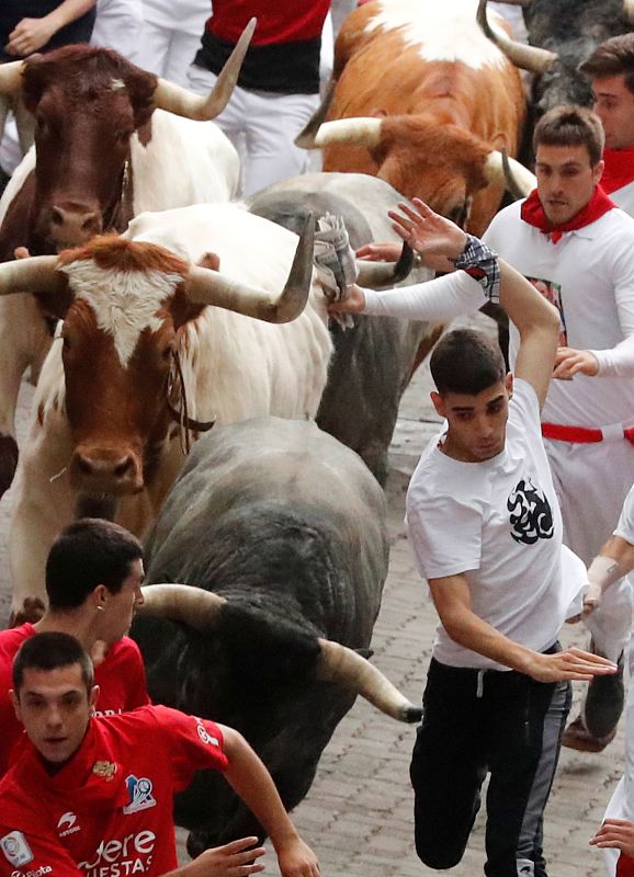 Un mozo hace un quiebro para esquivar una cornada