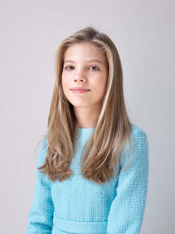 Sofía, con el cabello suelto, lleva un vestido azul celeste.