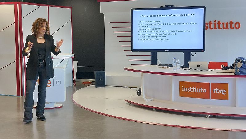 Cristina Ónega, directora del Canal 24h de TVE, presenta en un escenario moderno. Una pantalla detalla los Servicios Informativos de RTVE, mencionando más de 200 periodistas y seis áreas.